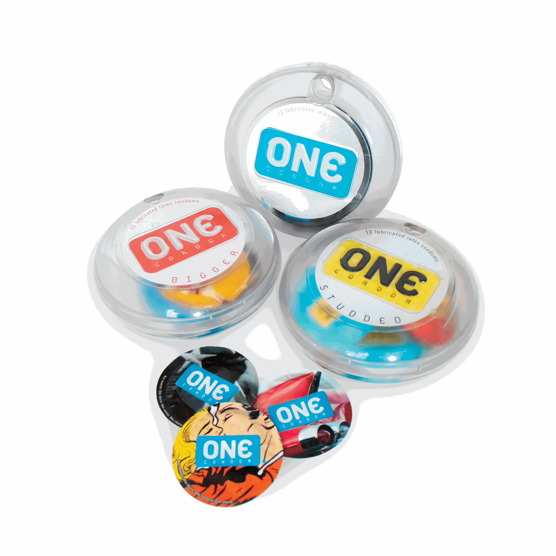 Condoms with the logo ONE in a round plastic case. Three condoms in front of them; all in round wrappers. ONE wrapper has a carm the other is black, the last one has a cartoon couple kissing